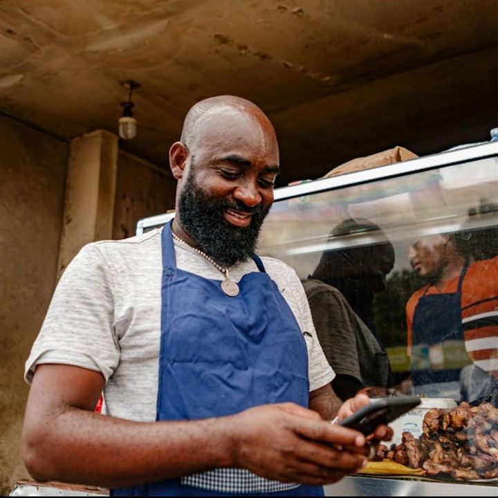 Un restaurateur qui consulte son téléphone devant son étal